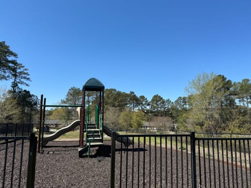 a playground with a jungle gym and slide in a park