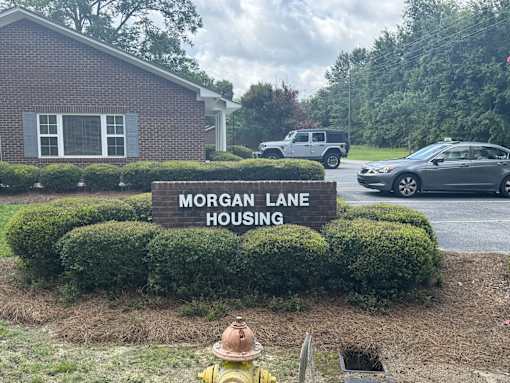 A sign that says Morgan Lane Housing in front of a building.