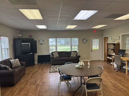 A spacious room with a table, chairs, and a television.