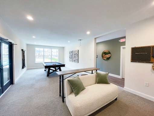 A living room with a white couch and a black table.