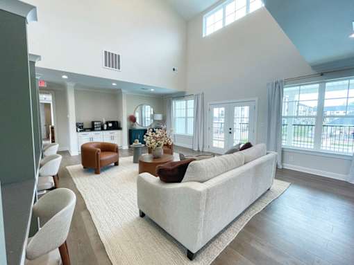 A spacious living room with a white couch and a large window.