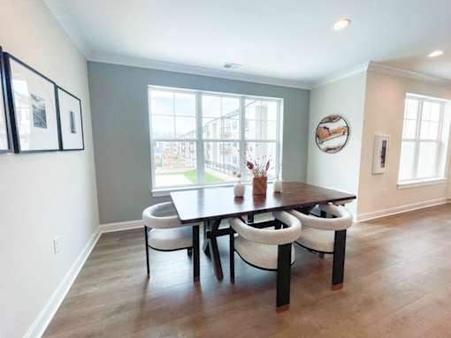 A dining room with a table and chairs.