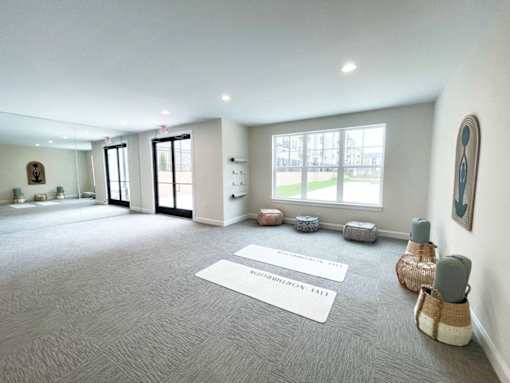 A spacious room with a carpet on the floor and a large window.