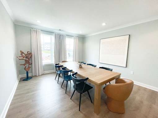 A dining room with a wooden table and chairs.