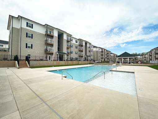 A large swimming pool in front of apartment buildings.
