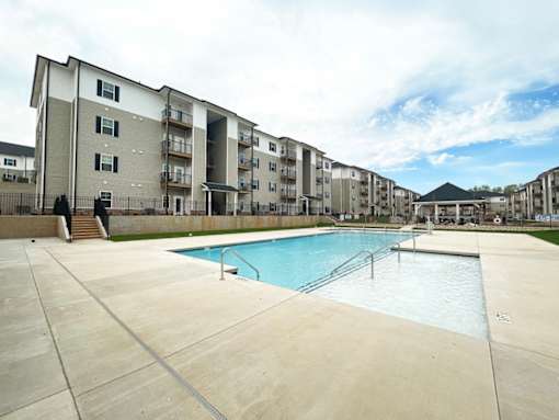 A large swimming pool in front of apartment buildings.