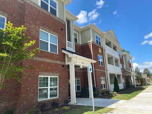 A row of townhouses with a blue sign in front.