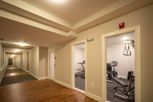 A hallway with a gym in the background.