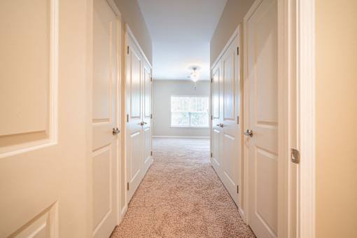 A long hallway with white doors on both sides.