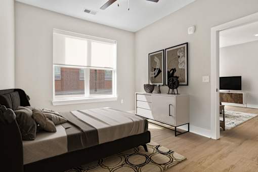 A bedroom with a bed, a dresser, and a window.