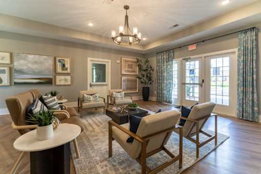A well-lit living room with a chandelier, sofas, and a coffee table.