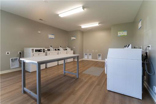 A clean, empty room with a table and a washing machine.