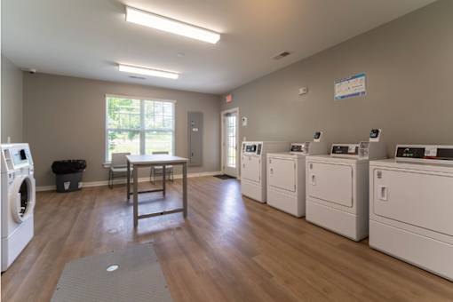 A laundromat with a row of washers and dryers.
