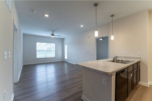 A kitchen with a countertop and a fan in the room.
