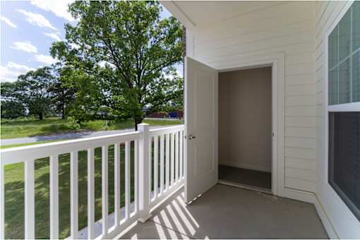 A white deck with a door leading to a patio.
