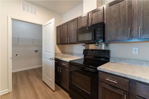 A kitchen with black appliances and wooden cabinets.