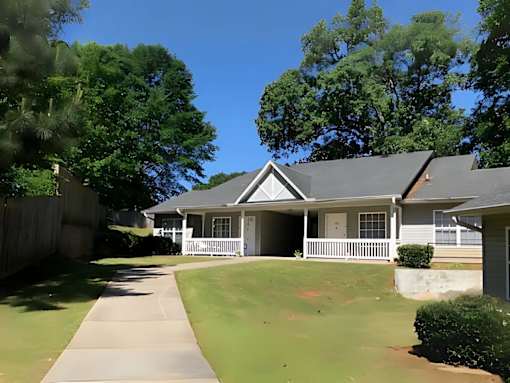 A house with a white fence and a green lawn.