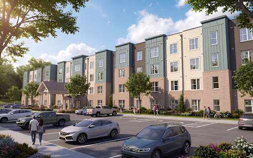 A row of modern townhouses with cars parked in front.