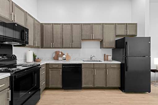A modern kitchen with black appliances and wooden cabinets.