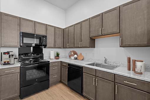 A kitchen with black appliances and wooden cabinets.