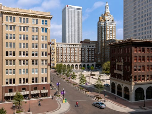 A city street with a car driving down it.