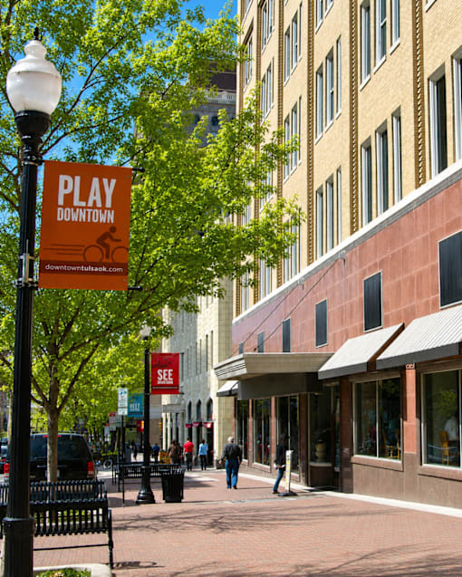 A sign that says Play Downtown is on a pole.