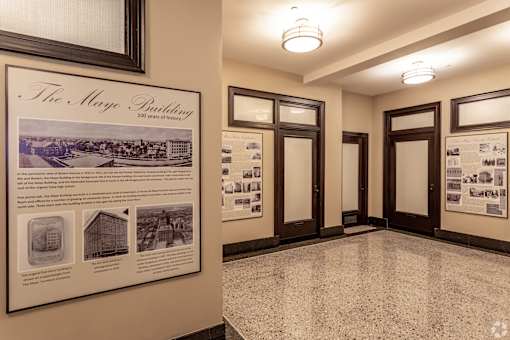 A wall with a framed poster and a picture of a building.