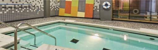 A small indoor pool with a metal ladder.