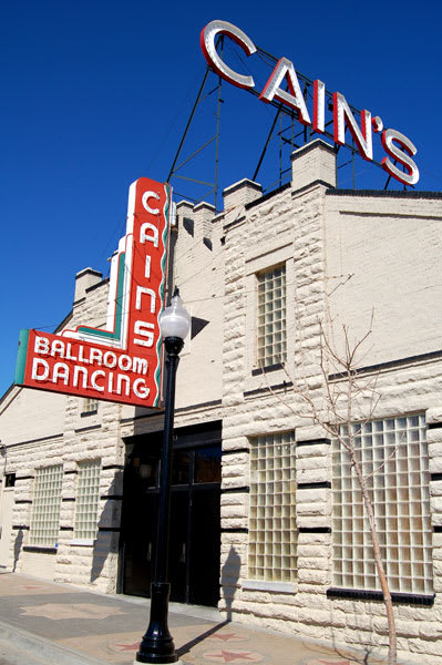 A white building with a sign that says Cains Ballroom Dancing.
