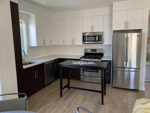 Apartment kitchen, dining area with built-in cabinets and stainless steel appliances