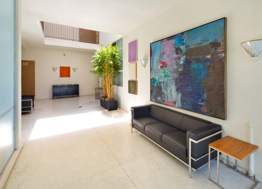 Apartment entry lobby with lush landscaping and artwork