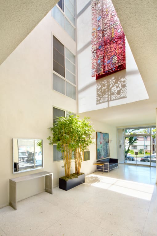 Apartment entry lobby with lush landscaping and artwork