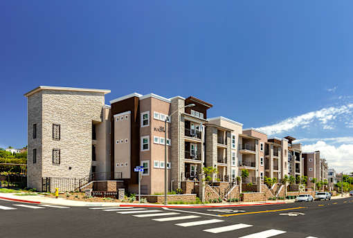 A row of apartment buildings with a blue sky in the background.