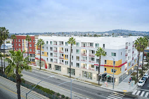 a large apartment building with palm trees in front of it