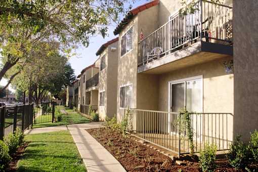 a row of apartments with balconies and a sidewalk