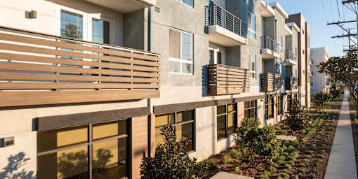 a row of apartment buildings with wooden balconies and a sidewalk