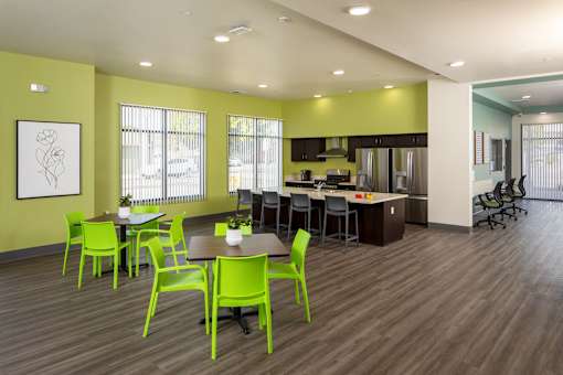 a dining room with green chairs and tables and a kitchen