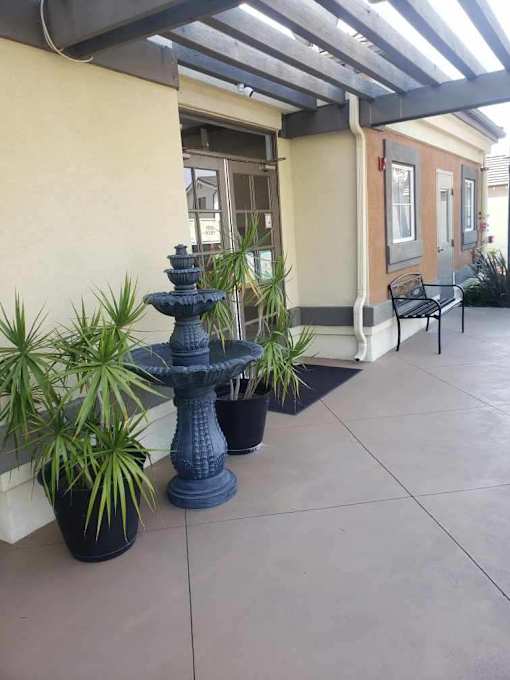 A blue fountain is in the middle of a patio.