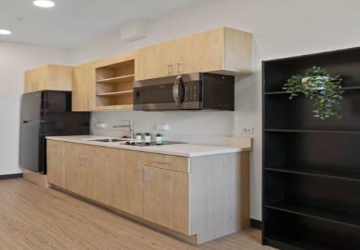 A kitchen with wooden cabinets and black appliances.