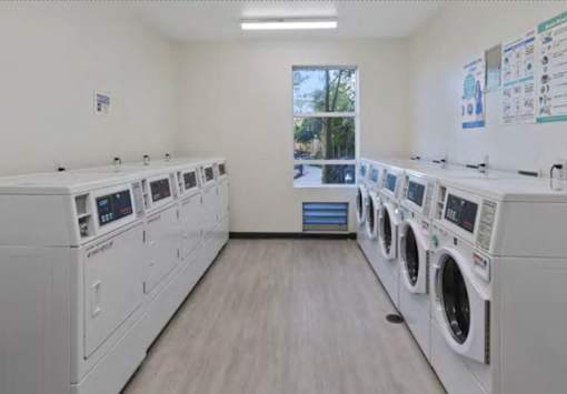 A row of white washing machines in a laundromat.