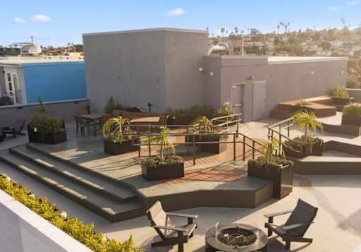 A patio with a fire pit and seating area.