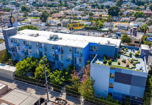 A blue and white apartment building with a sign that says "BMERO, MERO" on top.
