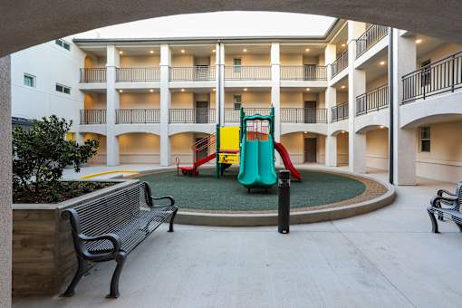 a playground in the middle of a hotel lobby with benches