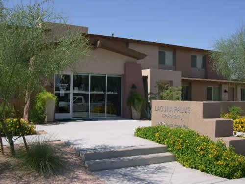 The image shows a building with a sign that reads "Laguna Pines Apartments.".
