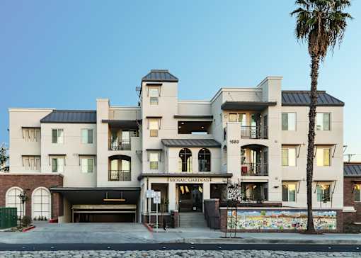 the front of a building with a palm tree in front of it
