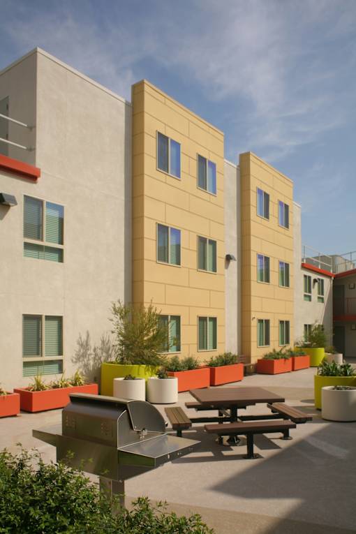 a courtyard with picnic tables in front of a building