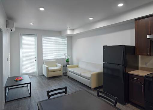 A modern kitchen with a black refrigerator and white appliances.