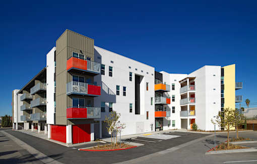 A modern multi-story building with a combination of white, grey, red, and yellow colors.
