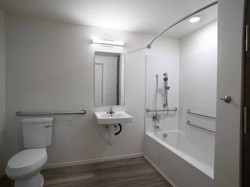 A white bathroom with a toilet, sink, and bathtub.
