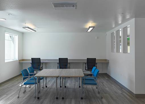 A conference room with a long table and chairs.